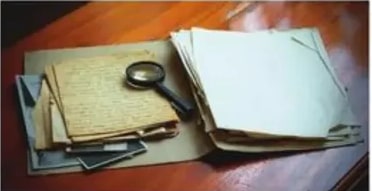 Documentos antiguos con lupa (estudio histórico).