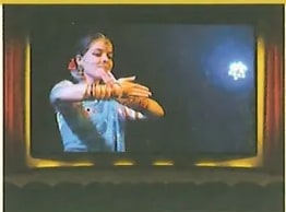 Fotografía de una actriz de danza clásica india (posiblemente Bharatanatyam) en escena, iluminada por un foco contra fondo oscuro. Ilustra el concepto de proyección y obra audiovisual/artística. Crédito: Pixabay.com.