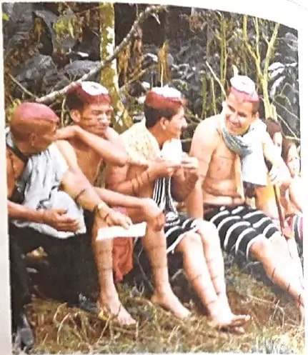 Fotografía de hombres de la comunidad shuar con pintura facial y vestimenta tradicional amazónica.
