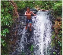 Fotografía de niño jugando en una cascada en Alto Tambo, Esmeraldas.