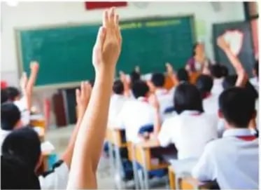 Estudiantes levantando la mano en clase.