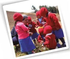Fotografía de una madre o docente trabajando junto a un niño pequeño en actividad de aprendizaje, posiblemente nivel inicial.