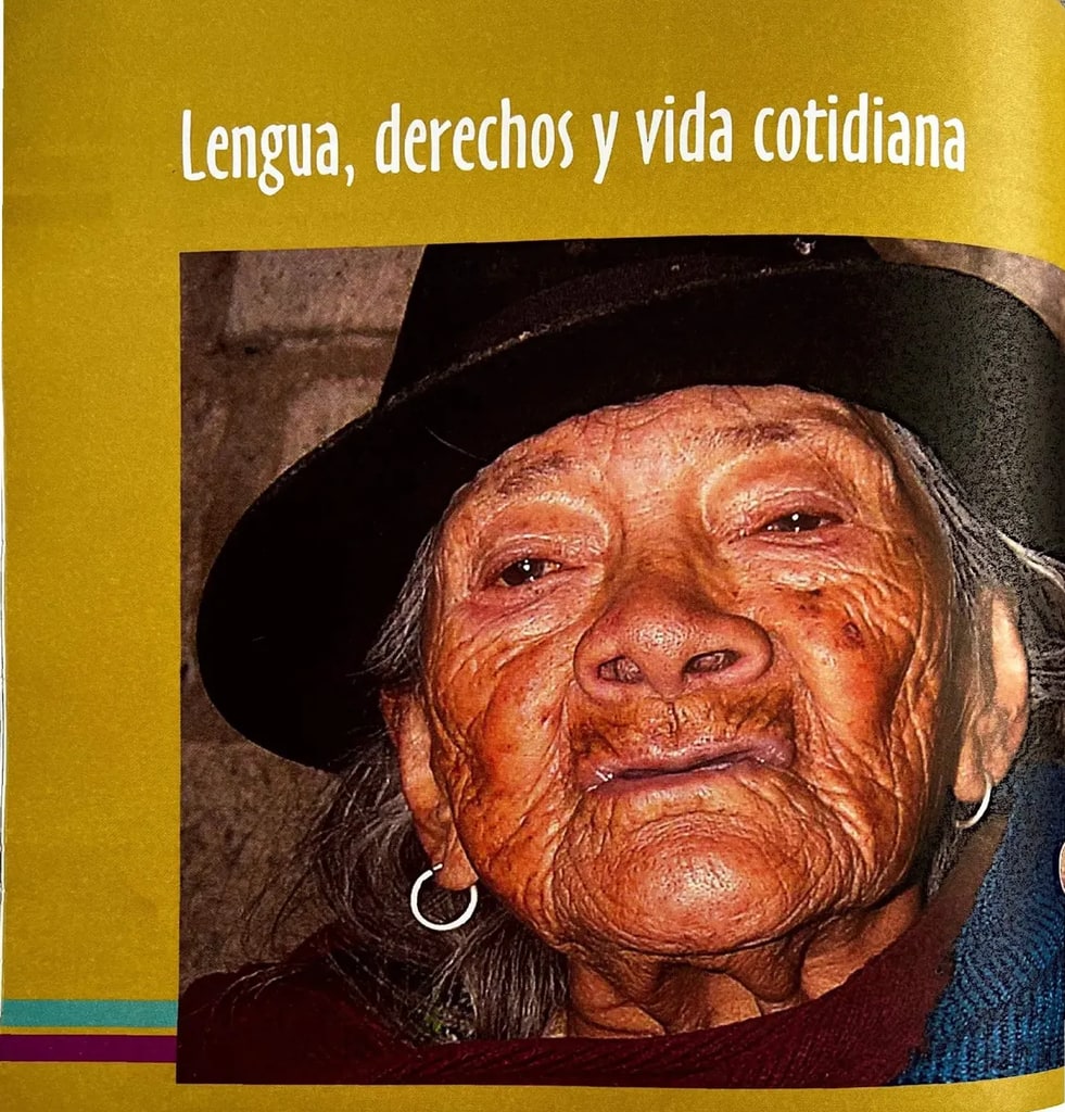 Retrato fotográfico en primer plano de una mujer indígena adulta mayor con sombrero negro y aretes, en tonos cálidos. Representa la diversidad cultural y lingüística del Ecuador.