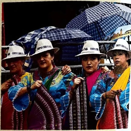 Fotografía a color de un grupo de mujeres indígenas con sombreros blancos y mantos coloridos, simbolizando la organización colectiva.