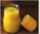 Vaso de chicha amarillenta junto a mazorca de maíz.