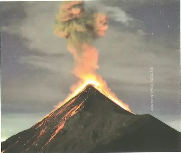 Pequeña fotografía en la esquina superior derecha de la página mostrando rocas volcánicas o lava solidificada de color oscuro rojizo/naranja. Ilustra los productos volcánicos descritos en el texto (lavas y/o piroclastos). La imagen complementa visualmente el contenido textual sobre tipos de lavas.