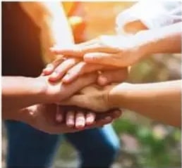 Manos juntas en señal de trabajo en equipo.