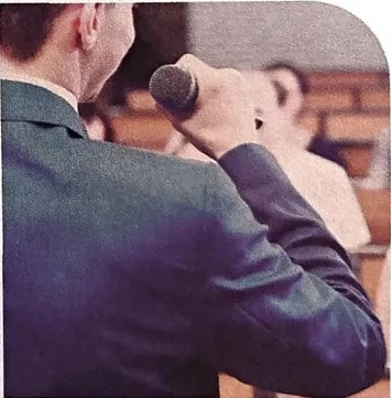 Fotografía de un orador en debate frente a una audiencia, asociada a la Unidad 4.
