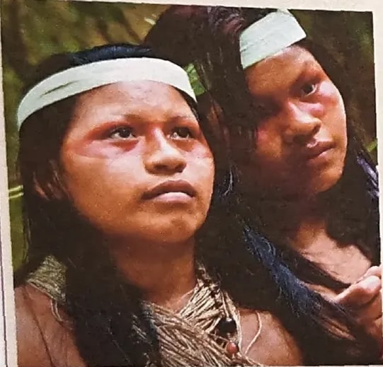 Fotografía de dos miembros (familia) de la nacionalidad awá con vestimenta tradicional y vinchas blancas.