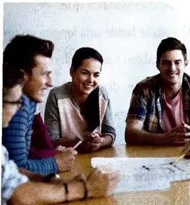 Foto de estudiantes alrededor de una mesa relacionada con la temática de comunicación.
