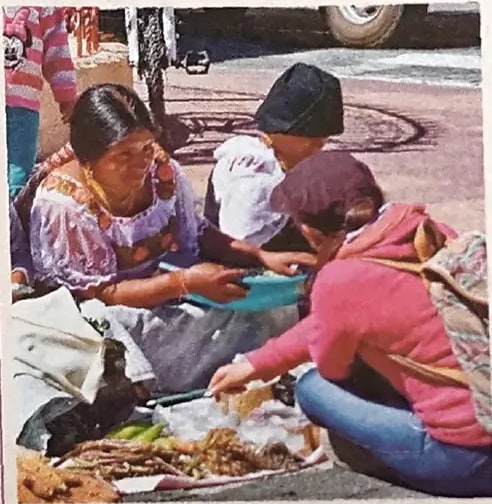 Fotografía de mujeres de Chibuleo en Ambato (Sierra) en actividad cotidiana con ropas tradicionales.
